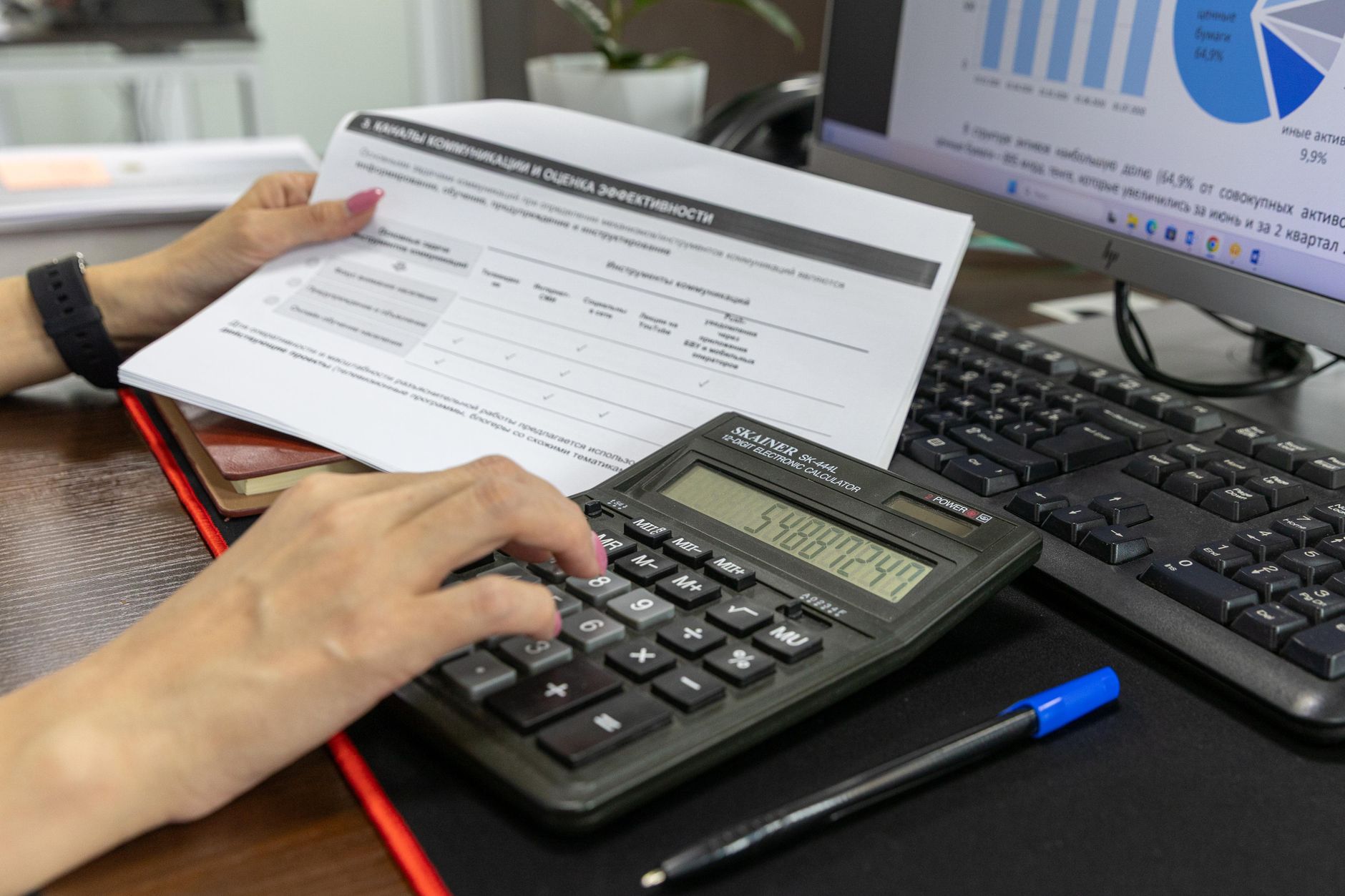 Un ordinateur portable ouvert sur un formulaire en ligne, à côté d'une pile de documents.