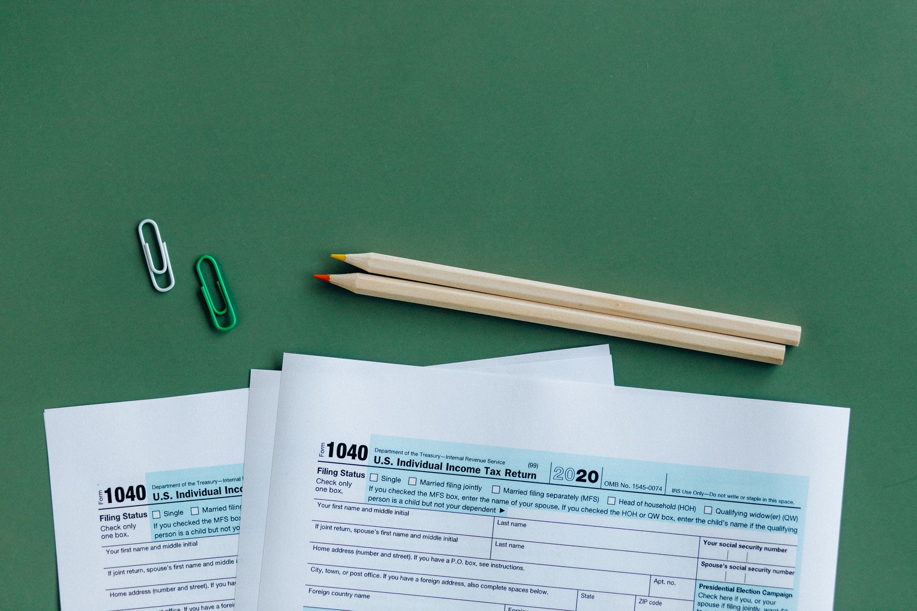 Des bulletins de paie et un avis d'imposition classés en piles sur un bureau.