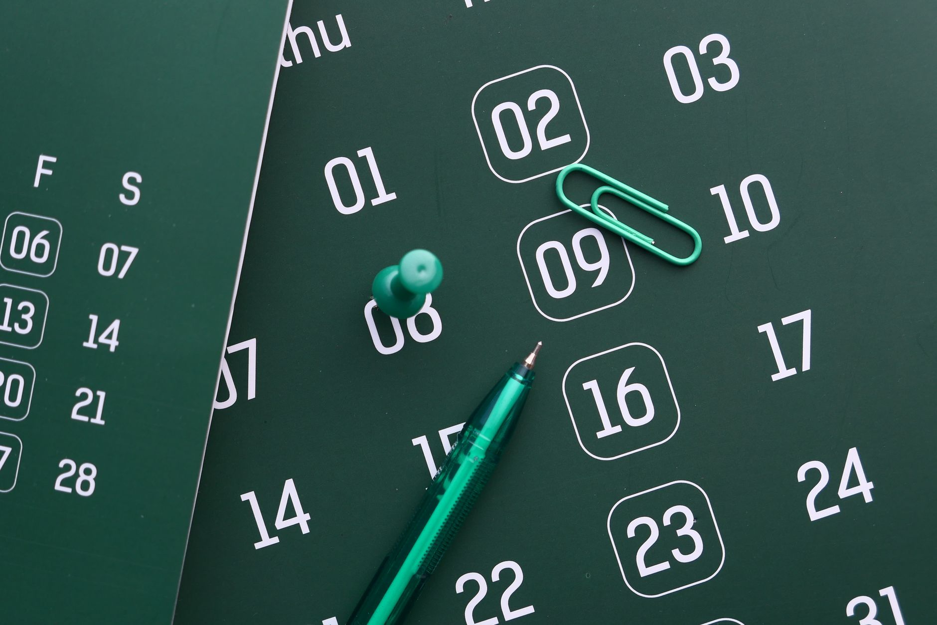 Calendrier mural avec une date entourée, à côté de documents administratifs
